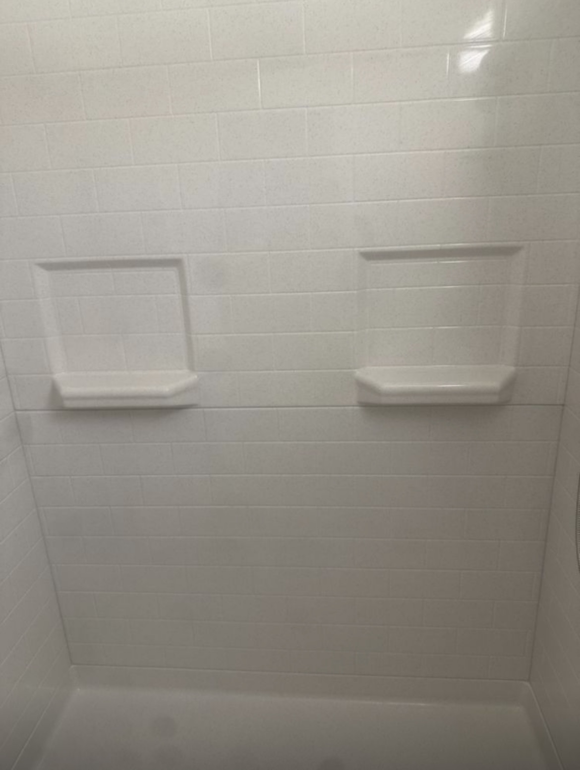 Sparkling clean white shower tile walls after restoration cleaning